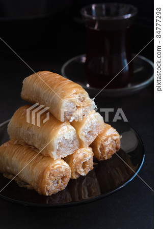 An image of Turkish baklava and a cup of tea in a low key. An image of Turkish baklava and a cup of tea in a low key. 84777298