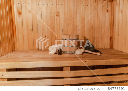 Traditional old Russian bathhouse SPA Concept. Interior details Finnish sauna steam room with traditional sauna accessories set basin towel aroma oil scoop felt. Relax country village bath concept Traditional old Russian bathhouse SPA Concept. Interior details Finnish sauna steam room with traditional sauna accessories set basin towel aroma oil scoop felt. Relax country village bath concept 84778391