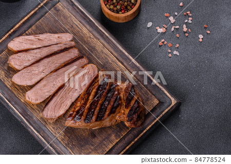 Cooked grilled Chuck eye roll steak on a chopping Board Cooked grilled Chuck eye roll steak on a chopping Board 84778524