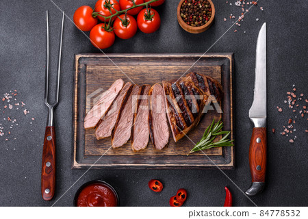 Cooked grilled Chuck eye roll steak on a chopping Board 84778532