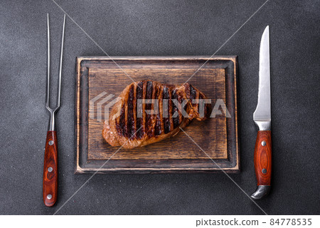 Cooked grilled Chuck eye roll steak on a chopping Board Cooked grilled Chuck eye roll steak on a chopping Board 84778535
