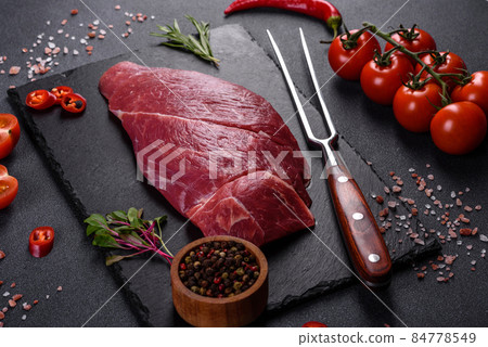 Raw fresh Chuck roll steak with herbs and salt on a cutting Board Raw fresh Chuck roll steak with herbs and salt on a cutting Board 84778549