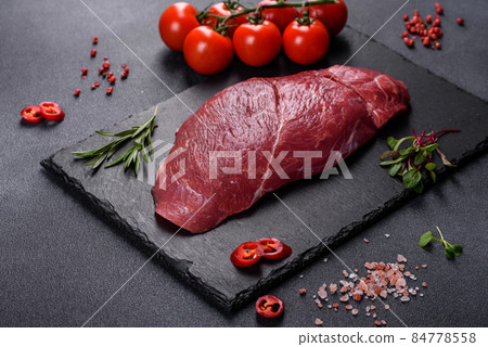 Raw fresh Chuck roll steak with herbs and salt on a cutting Board 84778558