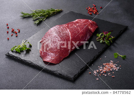Raw fresh Chuck roll steak with herbs and salt on a cutting Board Raw fresh Chuck roll steak with herbs and salt on a cutting Board 84778562