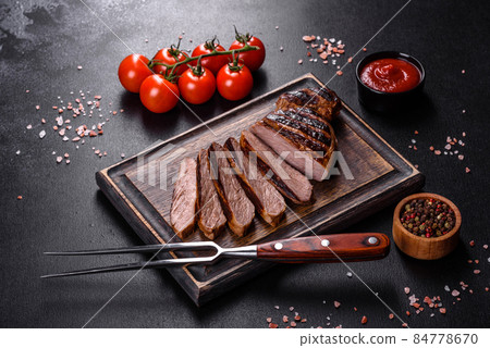 Cooked grilled Chuck eye roll steak on a chopping Board Cooked grilled Chuck eye roll steak on a chopping Board 84778670