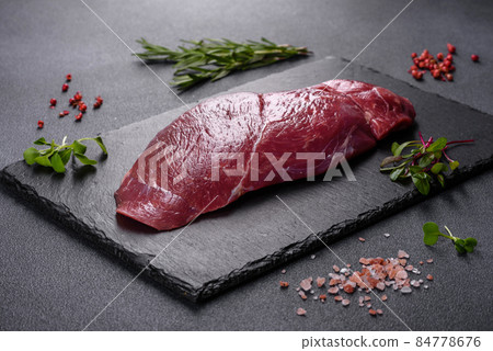 Raw fresh Chuck roll steak with herbs and salt on a cutting Board Raw fresh Chuck roll steak with herbs and salt on a cutting Board 84778676
