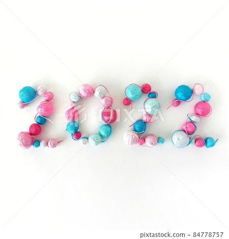 New Year 2022. Blue and pink balls of knitted yarn New Year 2022. Blue and pink balls of knitted yarn 84778757
