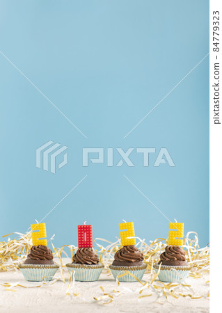 Homemade cupcakes and candles-numbers 2022 on blue background. Copy space. Vertical frame 84779323