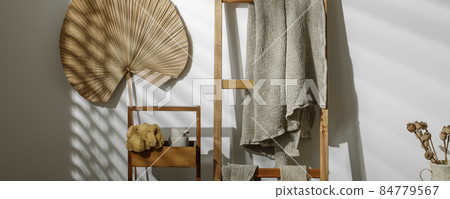 Organic handmade soap, waffle linen towels hanging on wood ladder, beige soap dispenser, exfoliating body strap and dried poppy flowers in textured vase. Zero waste bathroom accessories 84779567