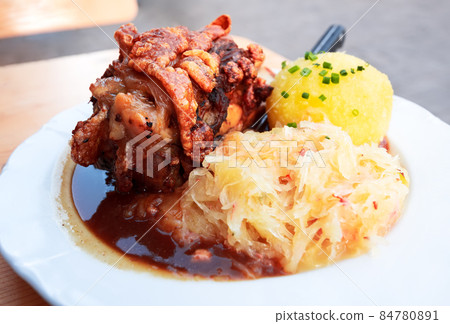 Schweinshaxe, German cuisine with pork knuckle, cabbage and pota 84780891