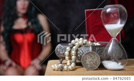 Vintage Jewelry Box with hourglass and Silver Dollar woman in corset in background Vintage Jewelry Box with hourglass and Silver Dollar woman in corset in background 84782085