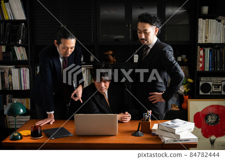 日本商人在一個團隊中工作，他們一邊看電腦一邊思考 84782444