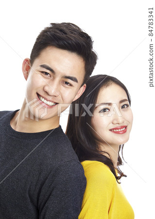 studio portrait of young asian couple, standing back to back, looking at camera smiling studio portrait of young asian couple, standing back to back, looking at camera smiling 84783341