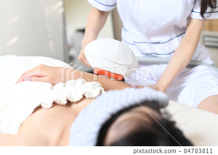 員工和女性顧客使用沙龍機器進行脫毛治療 員工和女性顧客使用沙龍機器進行脫毛治療 84783811