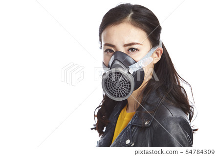 young asian woman in black leather jacket wearing a gas mask looking at camera, isolated on white 84784309