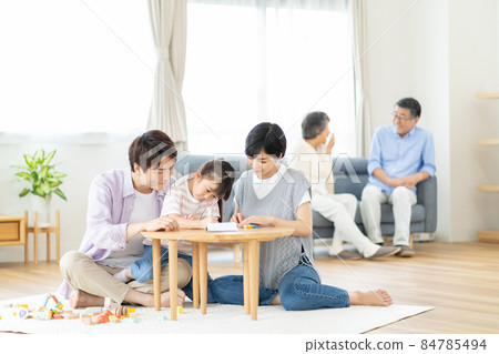 Three-generation family relaxing in the living room 84785494