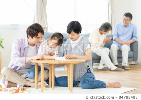Three-generation family relaxing in the living room 84785495