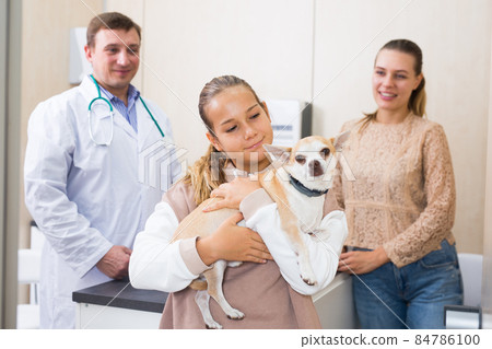 Portrait of happy mother and daughter consulting by professional veterinarian about their dog health 84786100