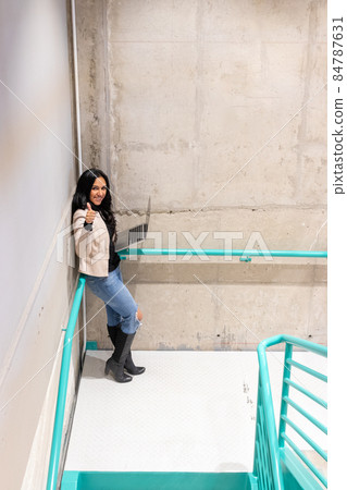 Brunette woman is working with her laptop from the stairs 84787631