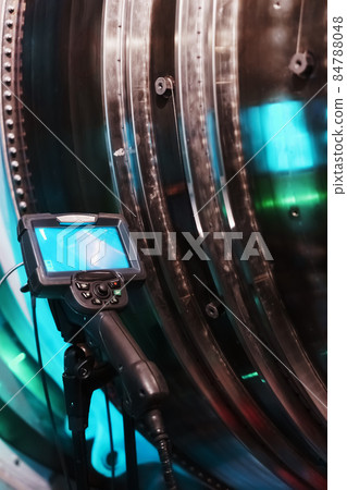 Borescope camera display on a tripod located at the turbine, Inspection of internal parts of a jet engine. 84788048