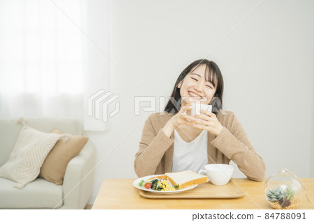 Woman eating breakfast (hot drink) Woman eating breakfast (hot drink) 84788091