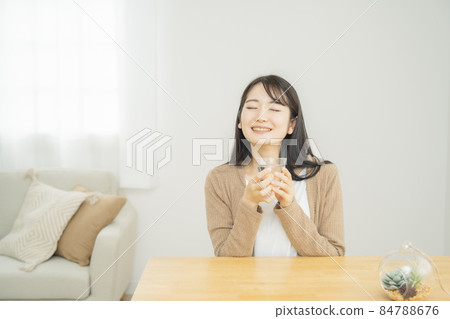 Japanese woman drinking water / hot water (smile) 84788676