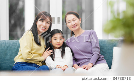 A three-generation family sitting side by side on the sofa A three-generation family sitting side by side on the sofa 84788718