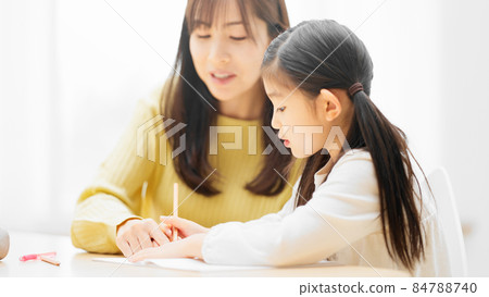 Daughter being taught to study by her mother 84788740