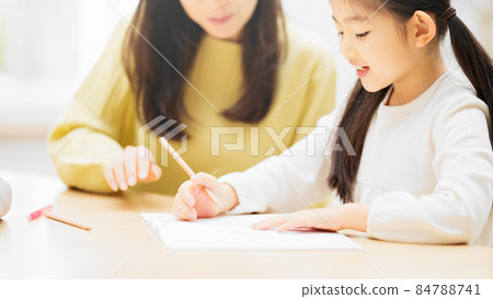Daughter being taught to study by her mother Daughter being taught to study by her mother 84788741