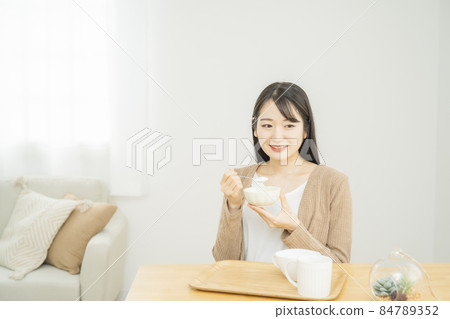 Woman eating yogurt Woman eating yogurt 84789352