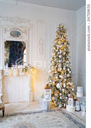 a large Christmas tree with boxes of gifts by the decorative fireplace a large Christmas tree with boxes of gifts by the decorative fireplace 84789656