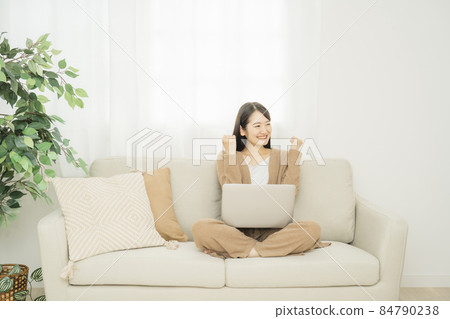 一個女人在家裡使用筆記本電腦(沙發膽量姿勢) 一個女人在家裡使用筆記本電腦(沙發膽量姿勢) 84790238