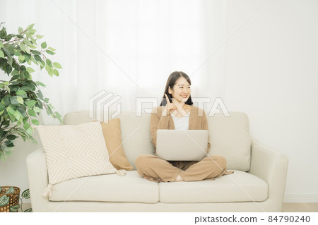 一個女人在家裡使用筆記本電腦(沙發) 一個女人在家裡使用筆記本電腦(沙發) 84790240