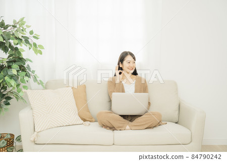 一個女人在家裡使用筆記本電腦(沙發) 一個女人在家裡使用筆記本電腦(沙發) 84790242