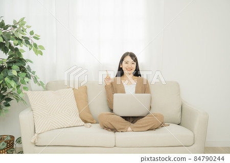 一個女人在家裡使用筆記本電腦(沙發) 一個女人在家裡使用筆記本電腦(沙發) 84790244