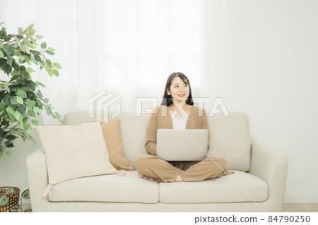 一個女人在家裡使用筆記本電腦(沙發) 一個女人在家裡使用筆記本電腦(沙發) 84790250