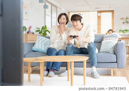 A young couple enthusiastic about online games leaving their kids alone 84791943