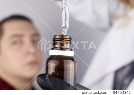 Close-up of eye drops. A man at the doctor appointment, who drips drops into the patient eyes. Concept treatment conjunctivitis, eye fatigue, glaucoma. Viral or bacterial infections Close-up of eye drops. A man at the doctor appointment, who drips drops into the patient eyes. Concept treatment conjunctivitis, eye fatigue, glaucoma. Viral or bacterial infections 84793542