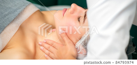 Massaging female neck. Young caucasian woman receiving neck massage relaxing in spa salon. Massaging female neck. Young caucasian woman receiving neck massage relaxing in spa salon. 84793974