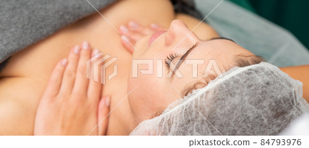 Massaging female chest. Young beautiful caucasian woman with closed eyes getting chest massage at beauty spa salon. Massaging female chest. Young beautiful caucasian woman with closed eyes getting chest massage at beauty spa salon. 84793976
