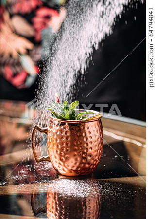 Bartender making cocktail in copper mug with sugar 84794841