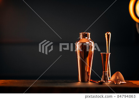 Copper bar tools set with shaker on wooden table 84794863