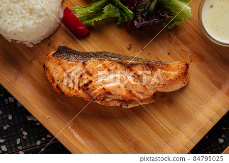 Grilled salmon steak with rice on wooden board 84795025