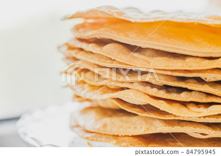 Baked crumpets cakes made of puff pastry for layer cake on a glass stand. Semi-finished product for cake. Close up, selective focus, shallow depth of field Baked crumpets cakes made of puff pastry for layer cake on a glass stand. Semi-finished product for cake. Close up, selective focus, shallow depth of field 84795945