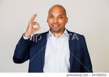 Young african american man smiling positively, making okay hand and fingers sign. Lucky expression Young african american man smiling positively, making okay hand and fingers sign. Lucky expression 84796650