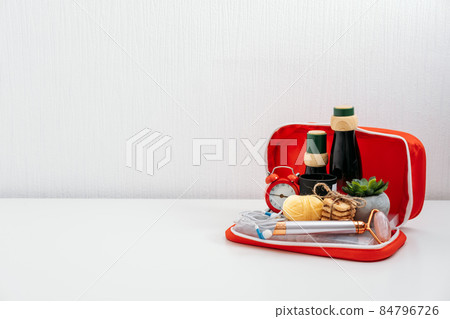 Self Care Kit, Self Care Package. Cosmetics bottles, face massager, sweets, headphones, scented candle and pencils for paint in red first aid kit. Devices for beauty, self care and leisure activities 84796726