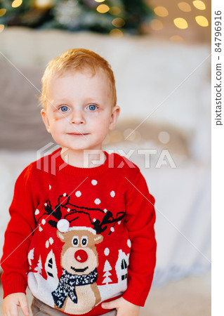 cute little boy with a bruise under his eye in a red Christmas sweater. cute little boy with a bruise under his eye in a red Christmas sweater. 84796916