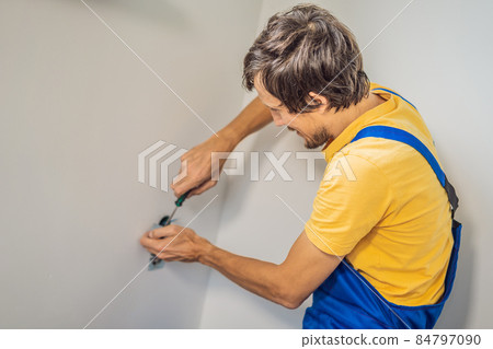 Master electrician installs a socket in the house 84797090