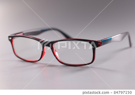 Fashionable plastic glasses red-black on gray background 84797150