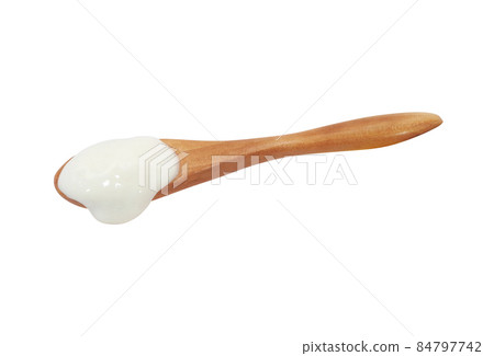 A lot of yogurt drips on a wooden spoon A lot of yogurt drips on a wooden spoon 84797742